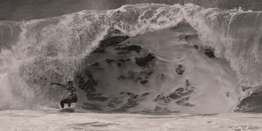 Surfer reitet riesige Welle im Meer.